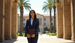 female student standing in front of university